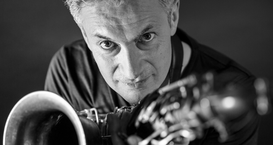 Jazz musician Dave O Higgins looks towards the camera in a black and white image