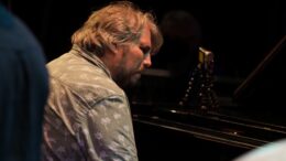 Jazz pianist Matt Ratcliffe plays the piano in a grey shirt