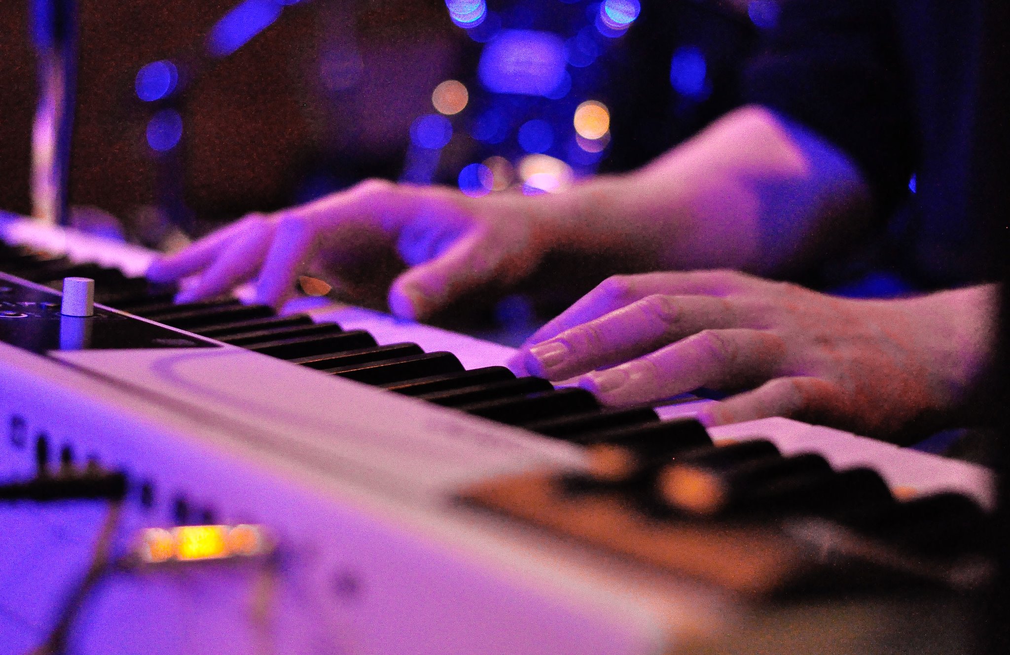 A pair of hands plays a keyboard